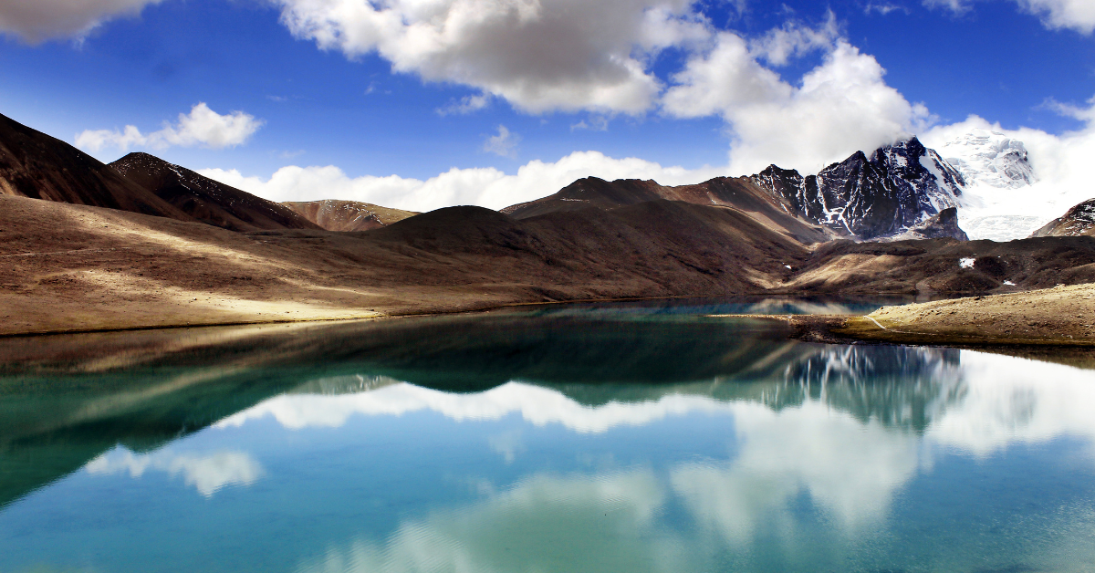 There is a lake in the middle of a mountain with a mountain in the background